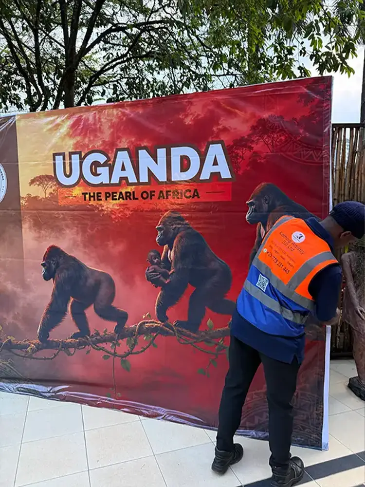 Installer securing the lower section of a reusable pop-up event backdrop stand for Feliz Tropical Safaris