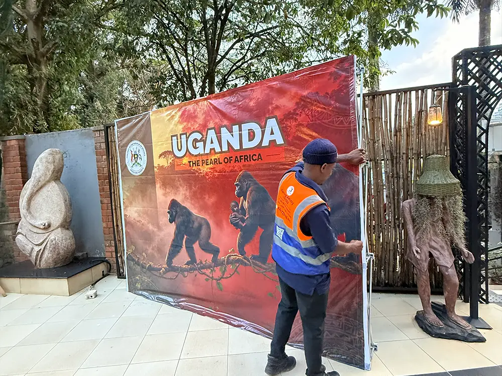 Final tensioning and adjustment of the Uganda tourism event backdrop at The Lawns Restaurant in Kampala