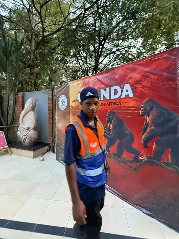 Kamog Artistry installer standing beside the completed Feliz Tropical Safaris event backdrop after same-day setup