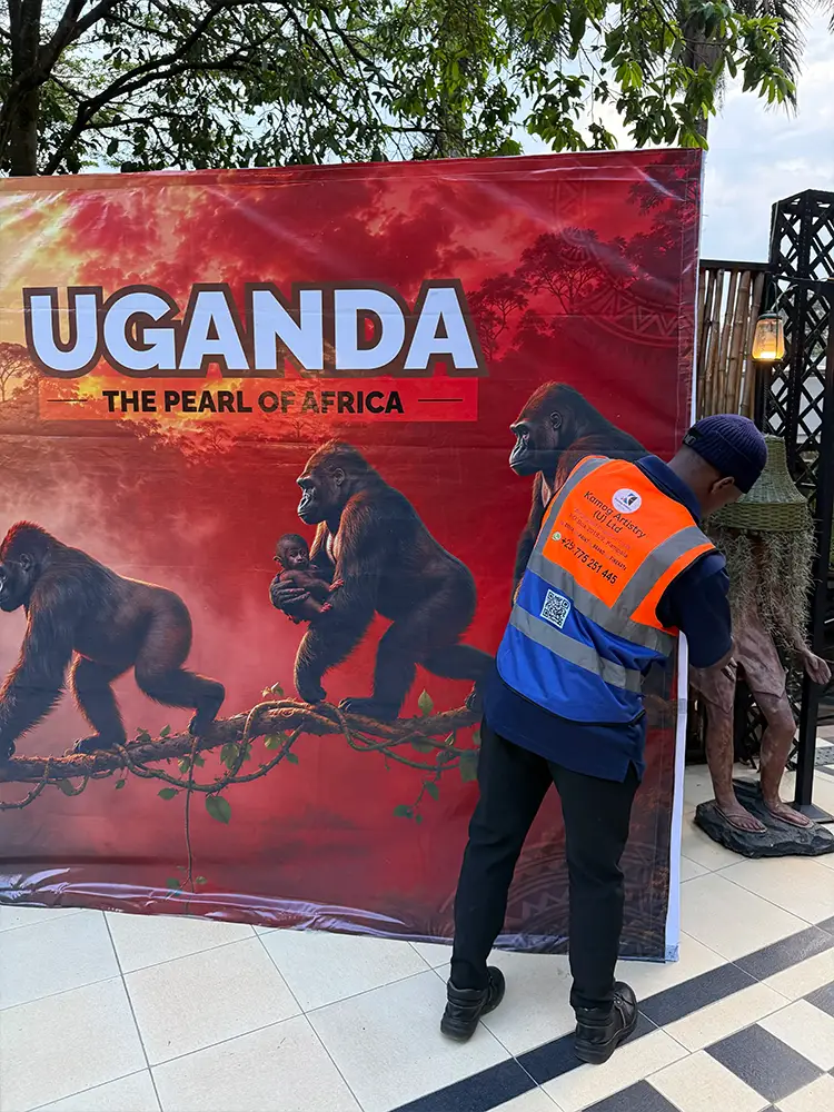 Final finishing and edge alignment of the Feliz Tropical Safaris tourism backdrop before the event