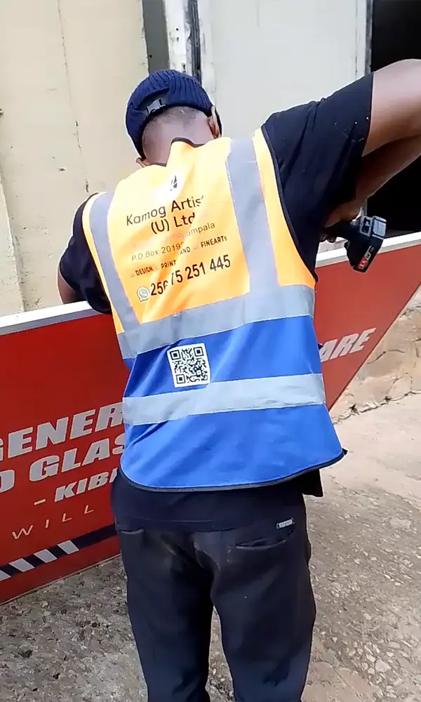 Cordless drilling during aluminium frame fastening on Goodwill signage