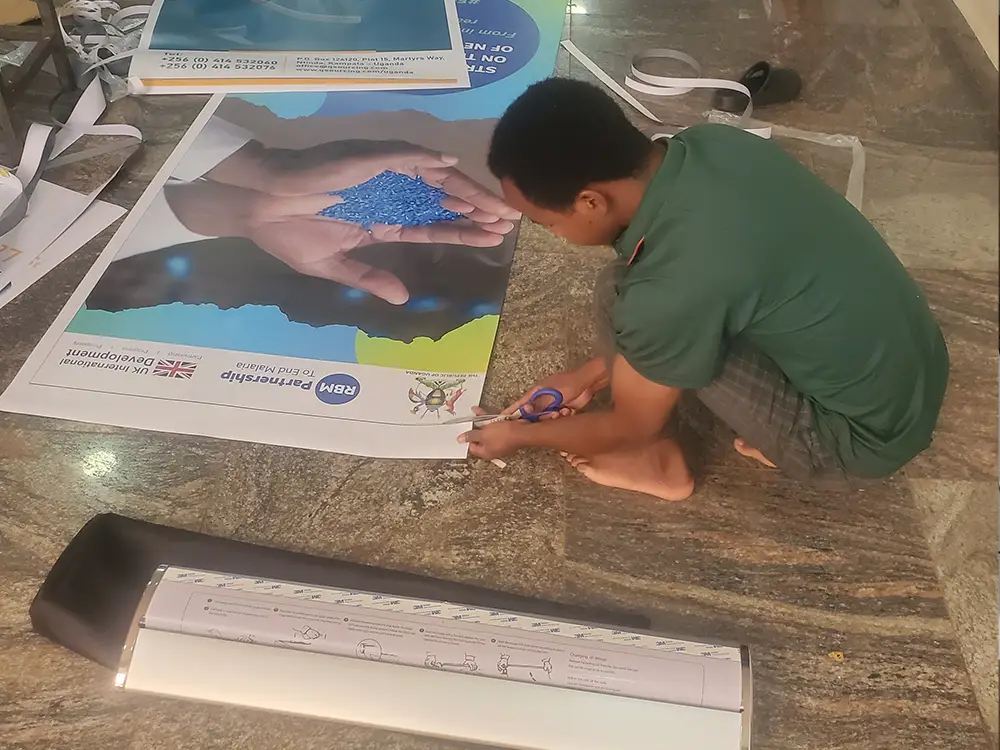 Roll up banner setup stage from RBM Partnership to End Malaria event branding case study by Kamog Artistry (U) Ltd