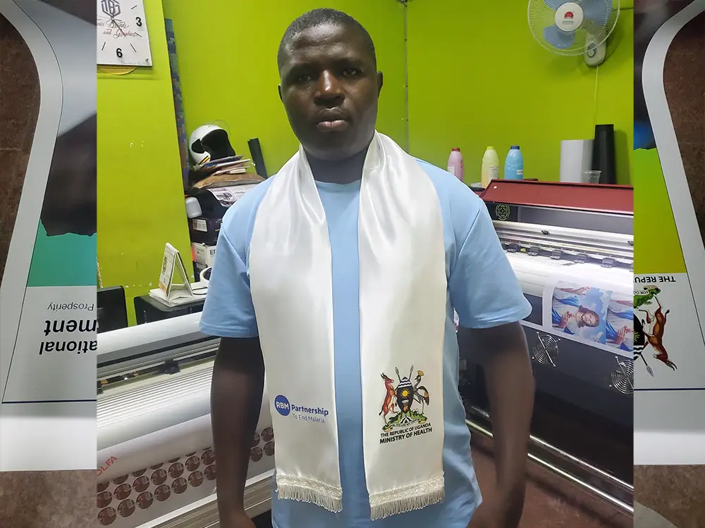 Kamog Artistry team with finished event branding materials for RBM Partnership to End Malaria conference in Kampala