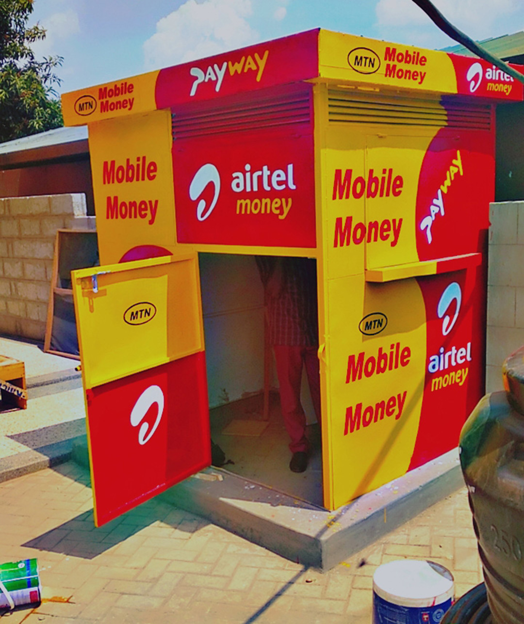 Mobile Money storefront branding in Central Uganda (MTN and Airtel painting workflow and protective finishing)