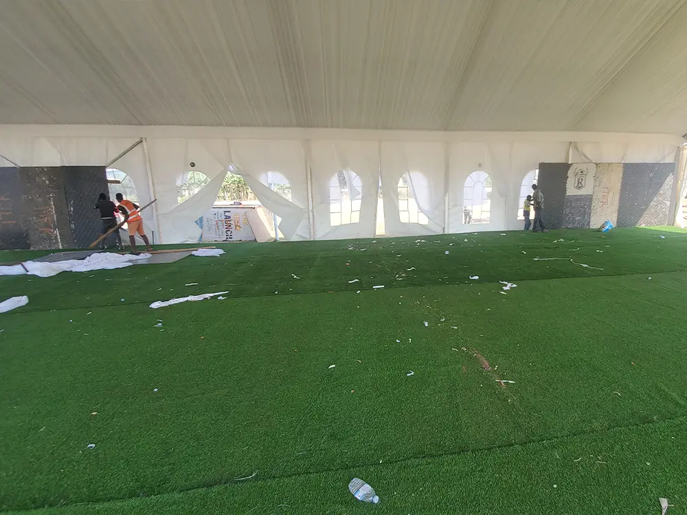 Wood panel backdrop setup — Wooden panel structures prepared inside the VIP tent before the wide PVC backdrop was stretched and fixed.