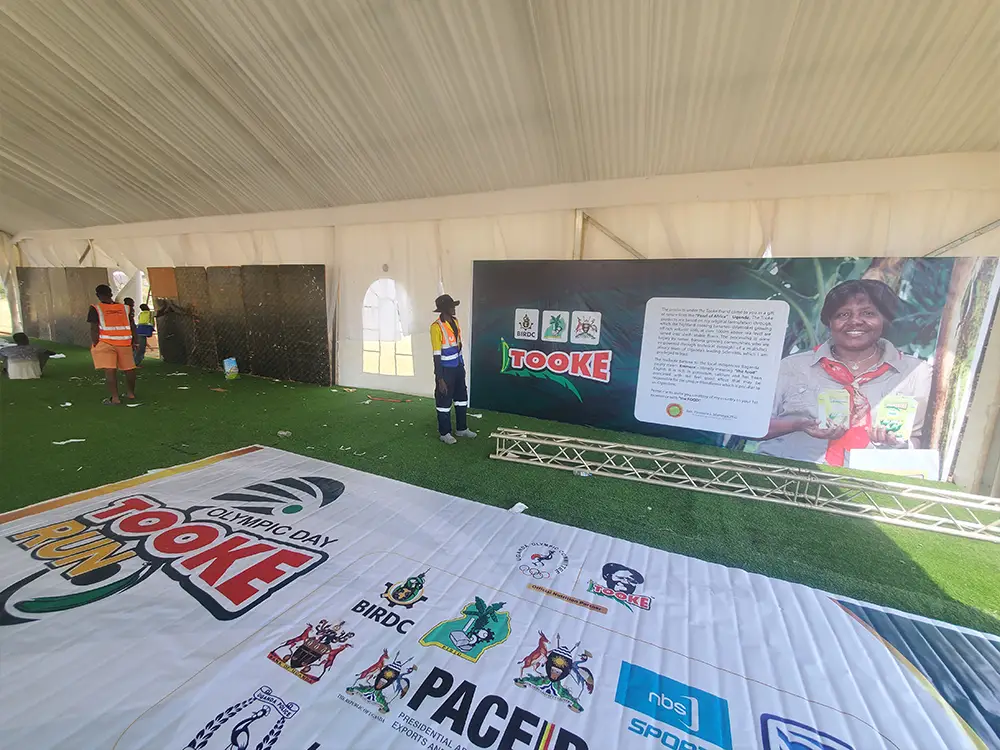 Kamog Artistry team in the VIP tent — On-ground event branding execution inside the VIP tent during the Bushenyi setup.