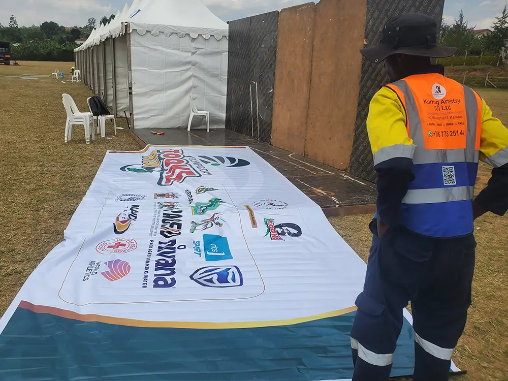 Sponsor print before installation — Sponsor-branded PVC for the photo backdrop prepared before fixing on the outdoor stand.