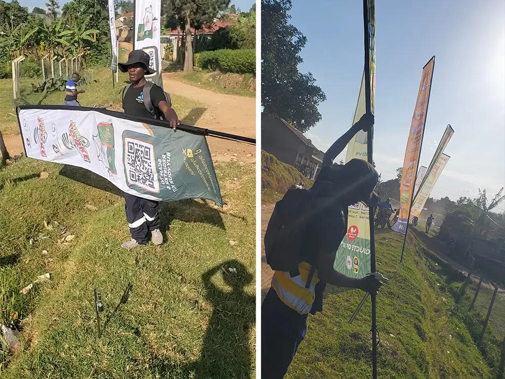 Outdoor installation outside the playground — A 6m / 19.7ft telescopic teardrop banner being positioned outside the Bushenyi playground area.