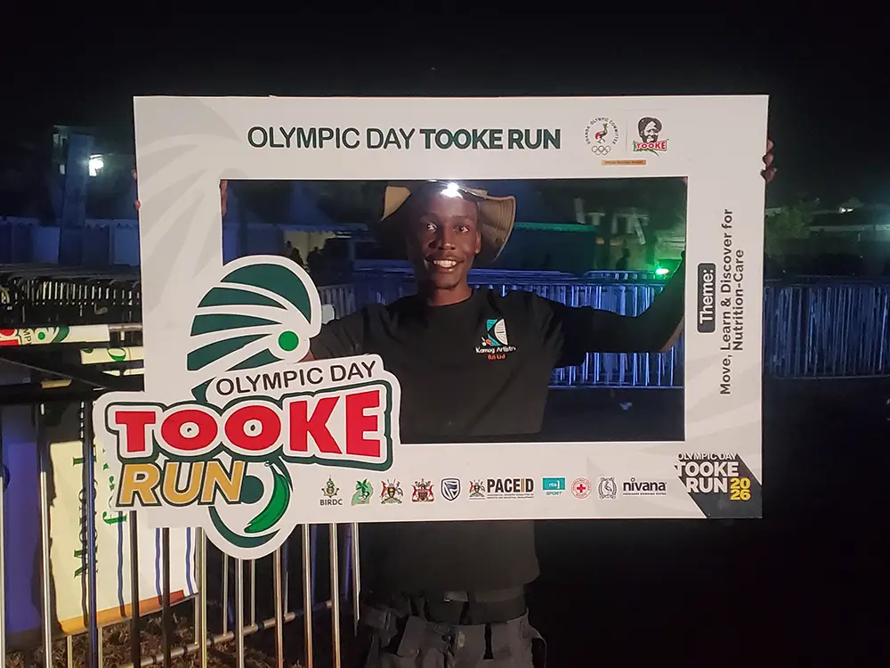 Team member holding event frame — Kamog Artistry team member showing one of the Tooke Run branded selfie frames during setup.