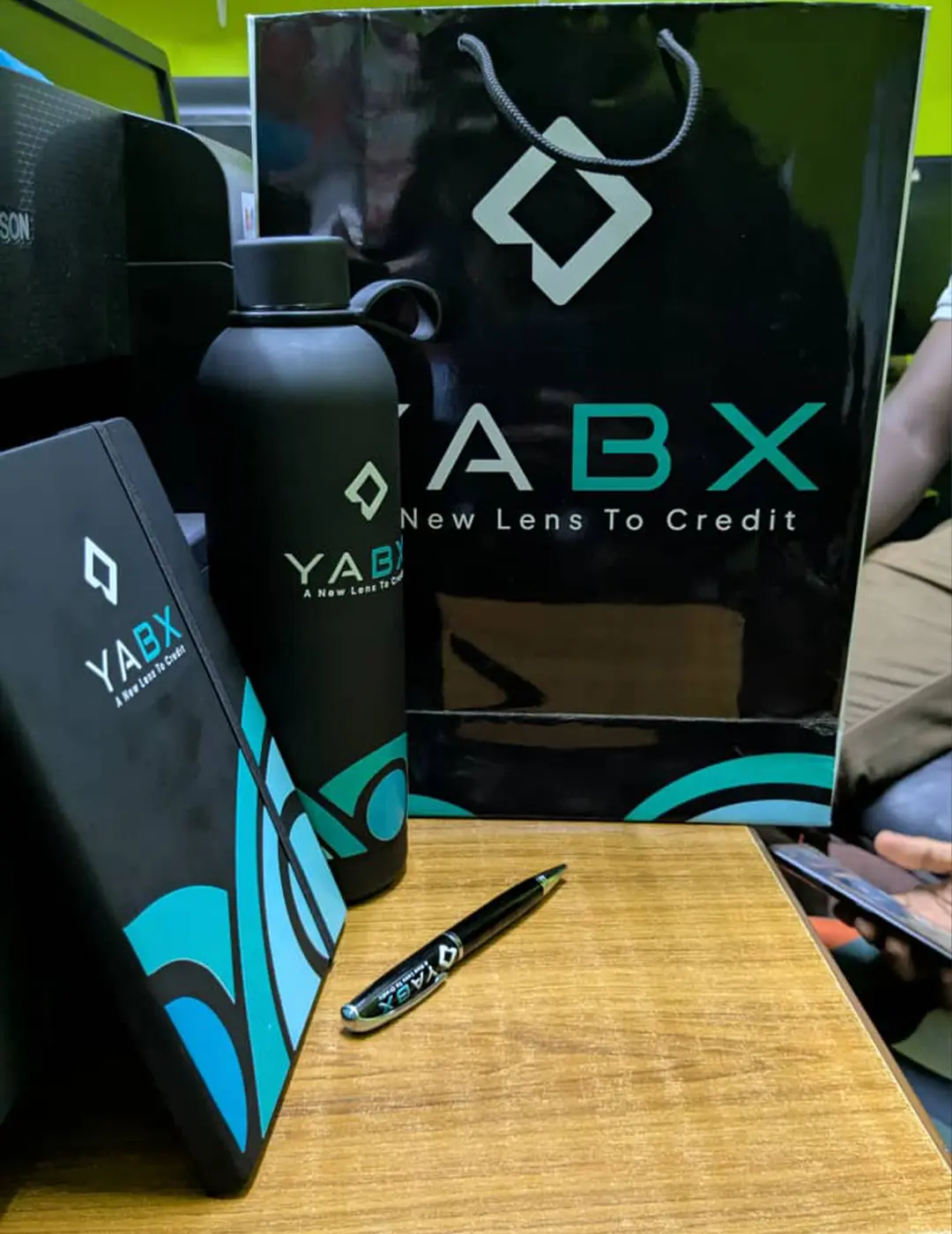 YABX custom corporate gift pack with branded notebook bottle pen and gift bag by Kamog Artistry (U) Ltd