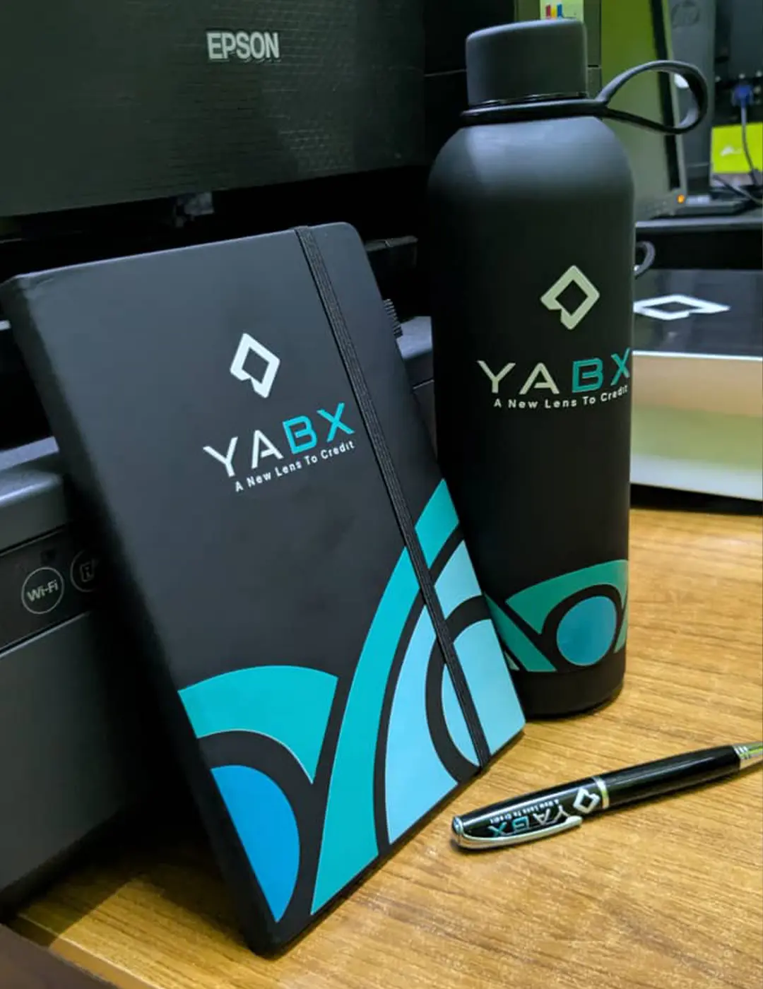 Custom merchandise pack with branded notebook bottle and logo pen for YABX